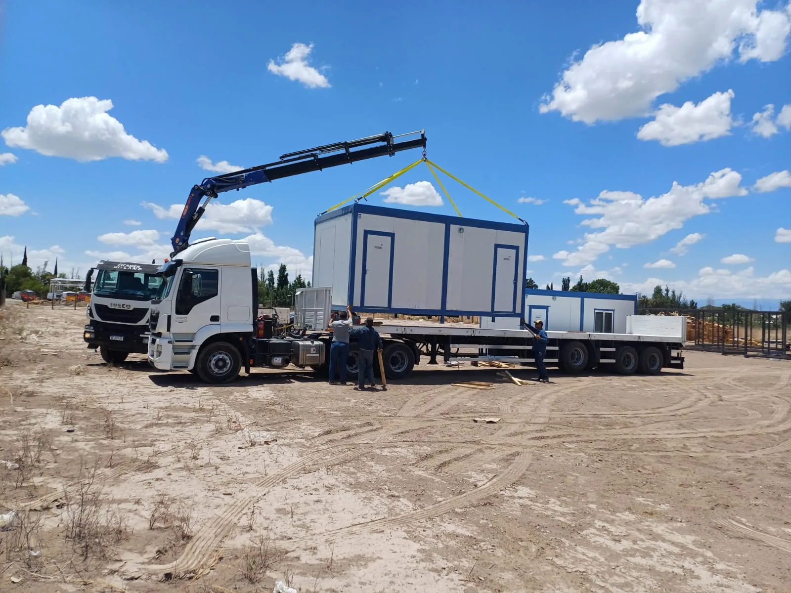 Módulo habitacional transportable tipo oficina minera, exterior con escalera de acceso, ambiente de campamento, fotografía realista