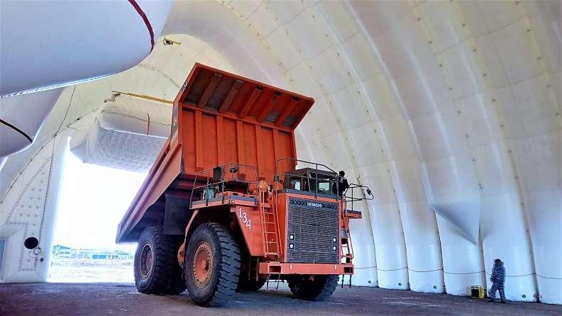 Camión minero volquete estacionado dentro de un hangar neumático HangAir
