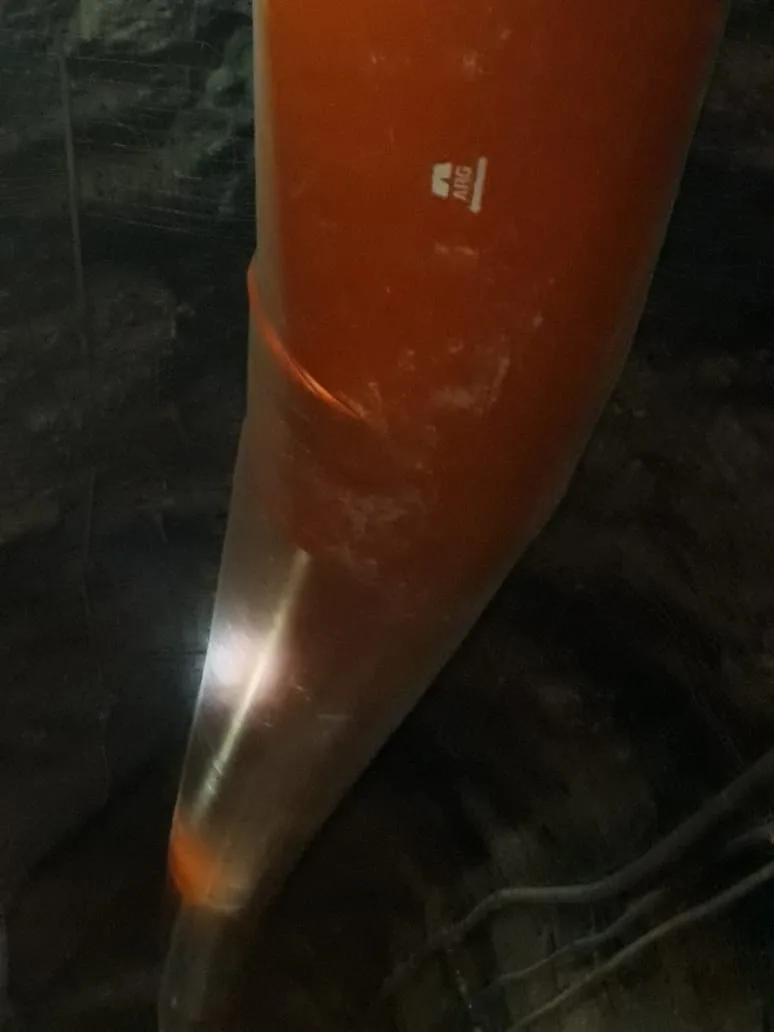 Manga impelente instalada y en operación en frente de mina, mineros trabajando al fondo, ambiente de roca