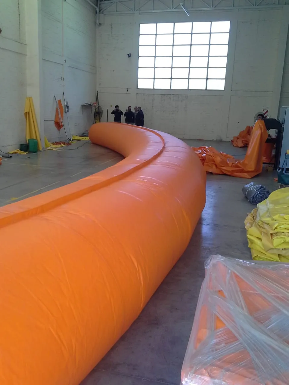 Detalle de la unión por aro metálico de una manga de ventilación de PVC, primer plano técnico con iluminación de taller